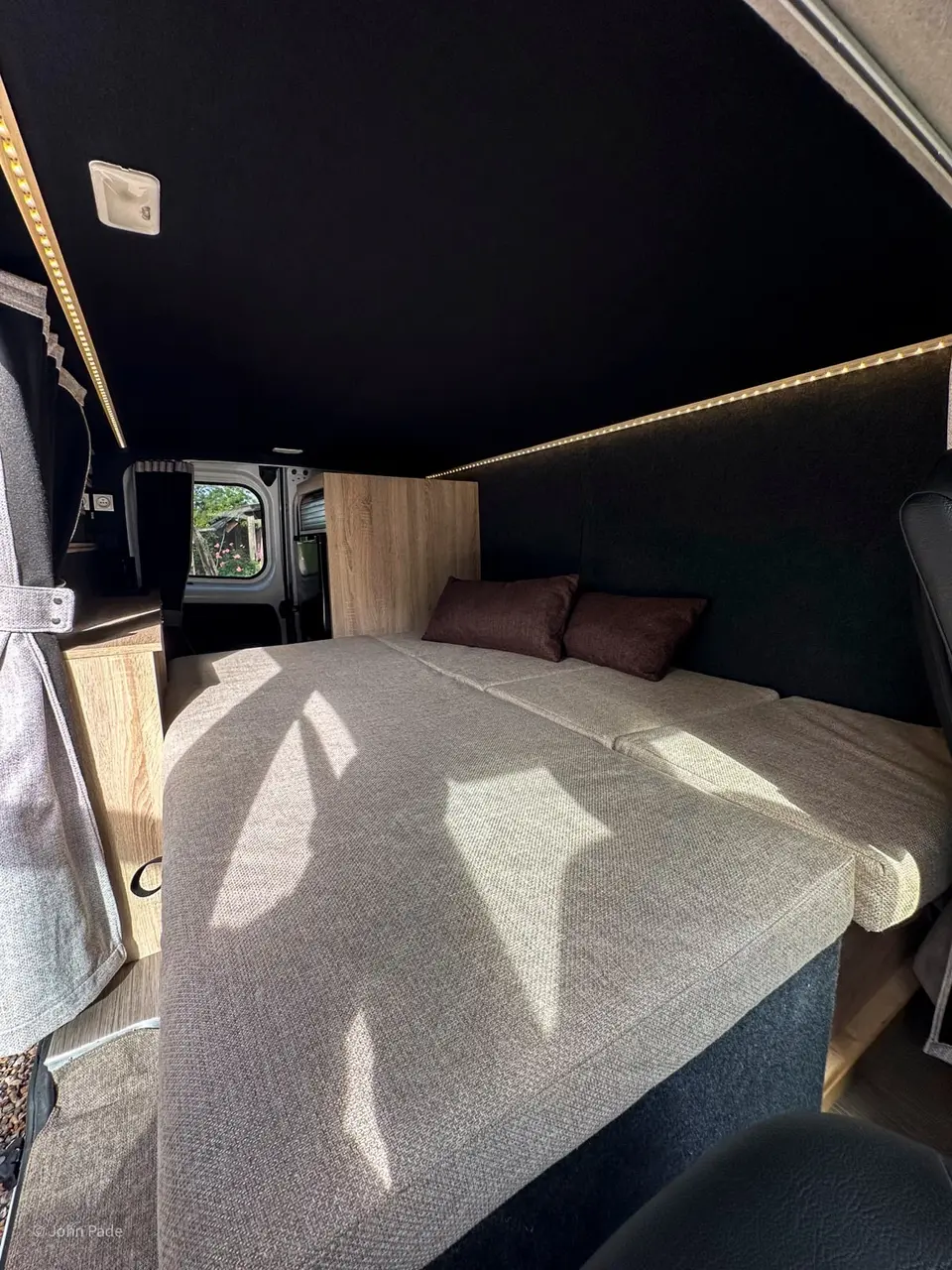 Lit fait avec coussins bruns sous l'éclairage LED