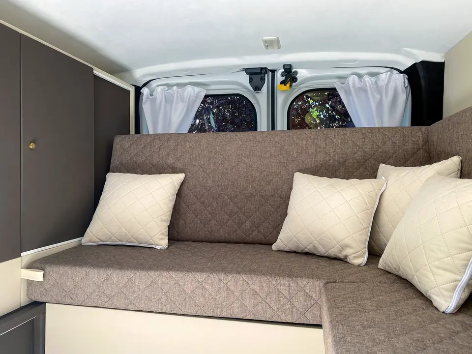 Banquette d'angle de van avec assises matelassées et coussins assortis, réalisée en 2023