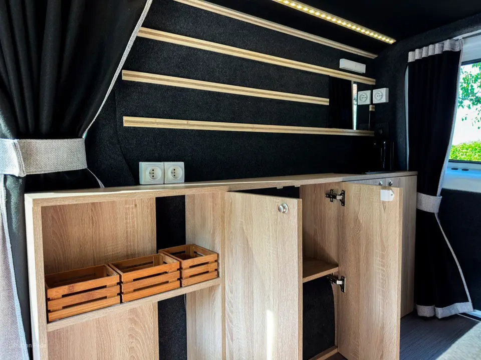 Intérieur de van entièrement aménagé par SVdL en 2025 : banquette, couchage et rangements sur mesure